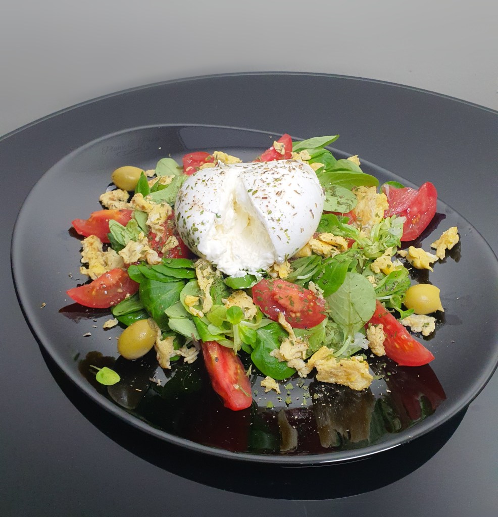 Salade de tomates et burrata sur son lit de mâche et oeufs brouillés
